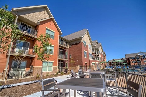 A sunny day at a residential complex here at Vue at Pinnacle Park with a pool and outdoor furniture.