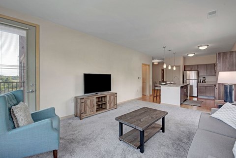 A living room with a blue chair and a wooden coffee table.