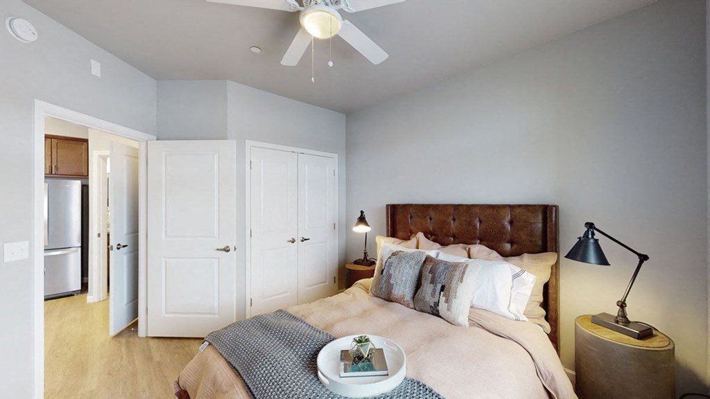 a bedroom with a bed and a ceiling fan