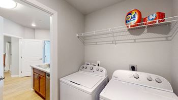 a laundry room with two washers and a dryer