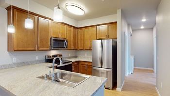 a kitchen with wooden cabinets and stainless steel appliances