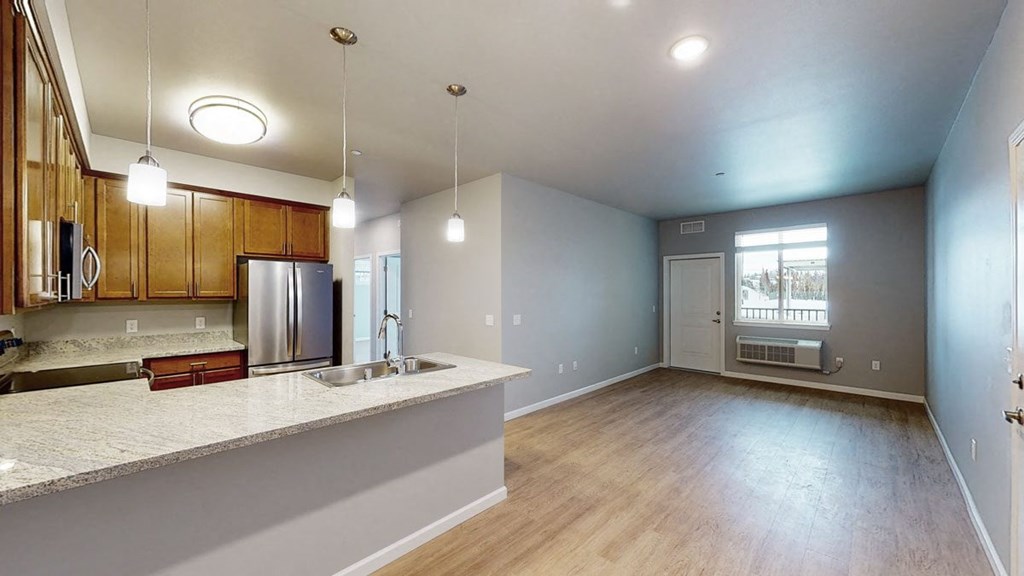 an empty kitchen and living room with a large window