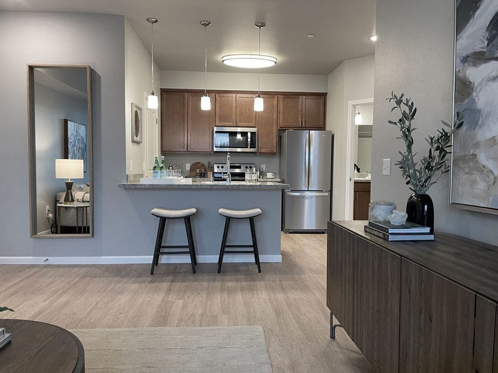 a kitchen with a bar and a stainless steel refrigerator