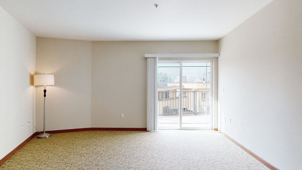 a bedroom with a sliding glass door and a lamp