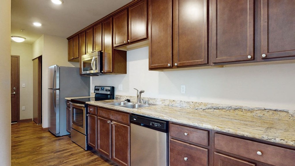 a kitchen with wooden cabinets and granite countertops