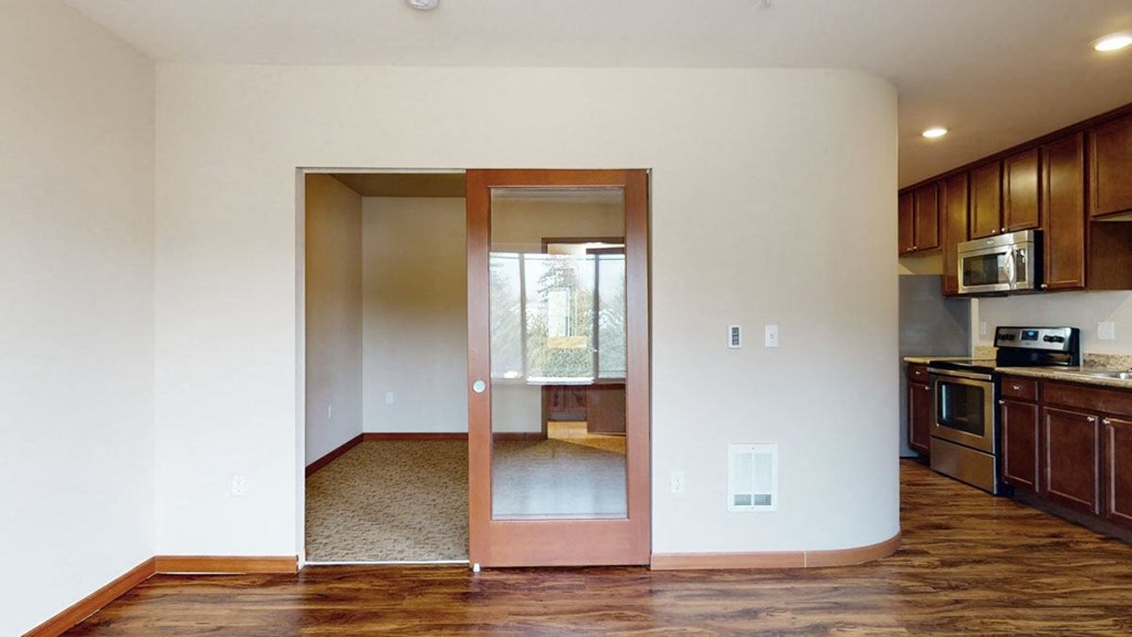 a kitchen and living room with wood floors and white walls