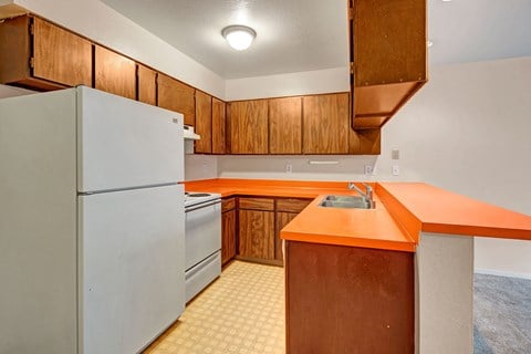a kitchen with an orange counter top and a white refrigerator