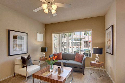 a living room with a couch and a table and a ceiling fan