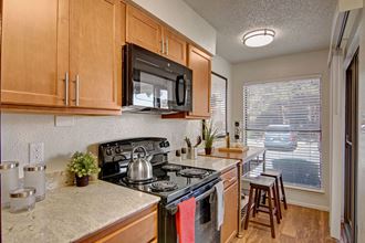 A kitchen with light cabinets and black appliances Motif Kitchen - Photo Gallery