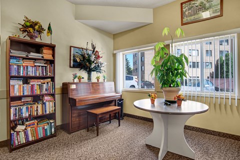 a living room with a piano and a table with a potted plant