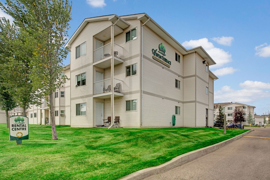 The exterior of the building surrounded by grass Aspen Terrace Exterior Apartments in Camrose, AB