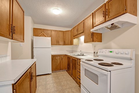 a kitchen with white appliances and wooden cabinets