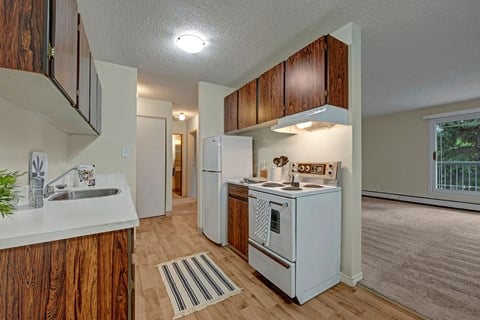 a kitchen with white appliances and a sink and a refrigerator
