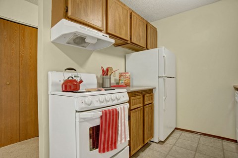 a kitchen with a white stove and a refrigerator