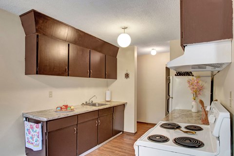 a kitchen with brown cabinets and white appliances and a stove