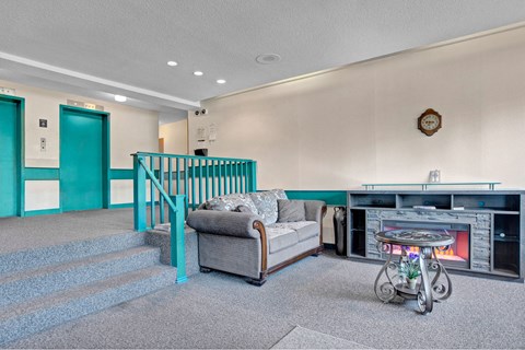 a living room with a couch and a fire place    and a staircase