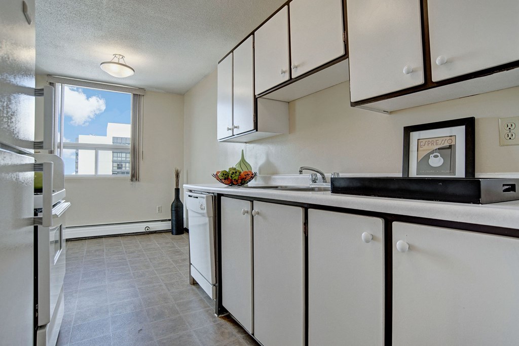 A kitchen with white appliances and white cabinetry Marquis Towers Apartment Homes Kitchen Apartments for rent in Saskatoon, SK