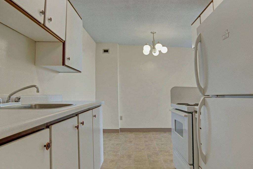 A kitchen with white appliances and white cabinetry Marquis Towers Apartment Homes Kitchen Apartments for rent in Saskatoon, SK