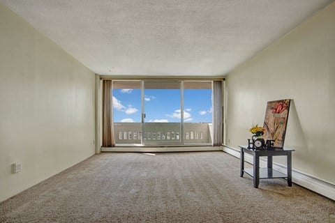 a living room with a large window and a painting on a table