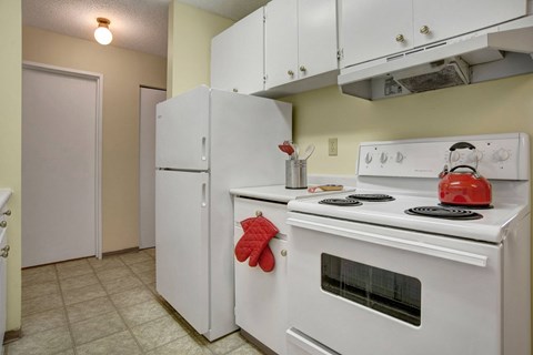 a kitchen with white appliances and a white stove and refrigerator