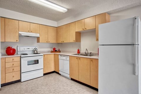 a kitchen with white appliances and wooden cabinets