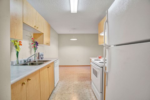 a kitchen with white appliances and wooden cabinets