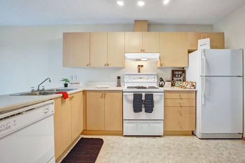 a kitchen with white appliances and wooden cabinets