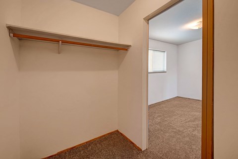the upstairs bedroom has a closet with a mirror and a window