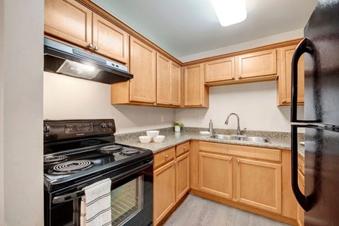 full kitchen with black appliances and wood cabinets and granite counter tops
