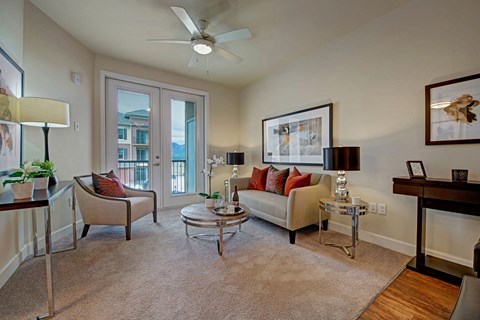a living room with a couch and chairs and a ceiling fan
