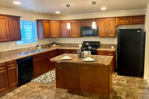 a kitchen with wooden cabinets and a black refrigerator