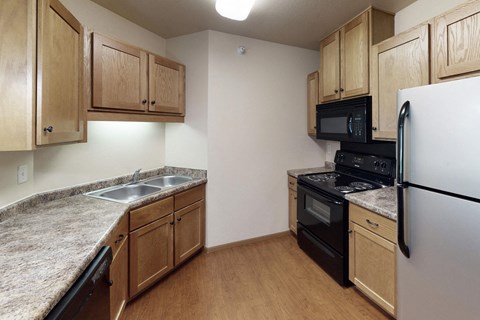 a kitchen with granite counter tops and black appliances