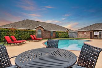 A pool surrounded by lounge chairs and tables for resident use Lexington Court Exterior Apartments for rent Abilene, Texas
