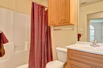 A bathroom with a bathtub and shower combination and additional cabinet storage Lexington Court Bathroom Abilene Apartments
