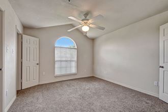 A large bedroom with a ceiling fan and wide window Lexington Court Bedroom Abilene, Texas Apartments for rent