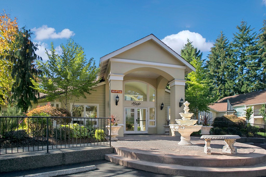 Entrance to the main office of Adagio with greenery, a decorative fountain, and benches Adagio Apartment Homes Leasing Office Apartments in Bellevue, WA