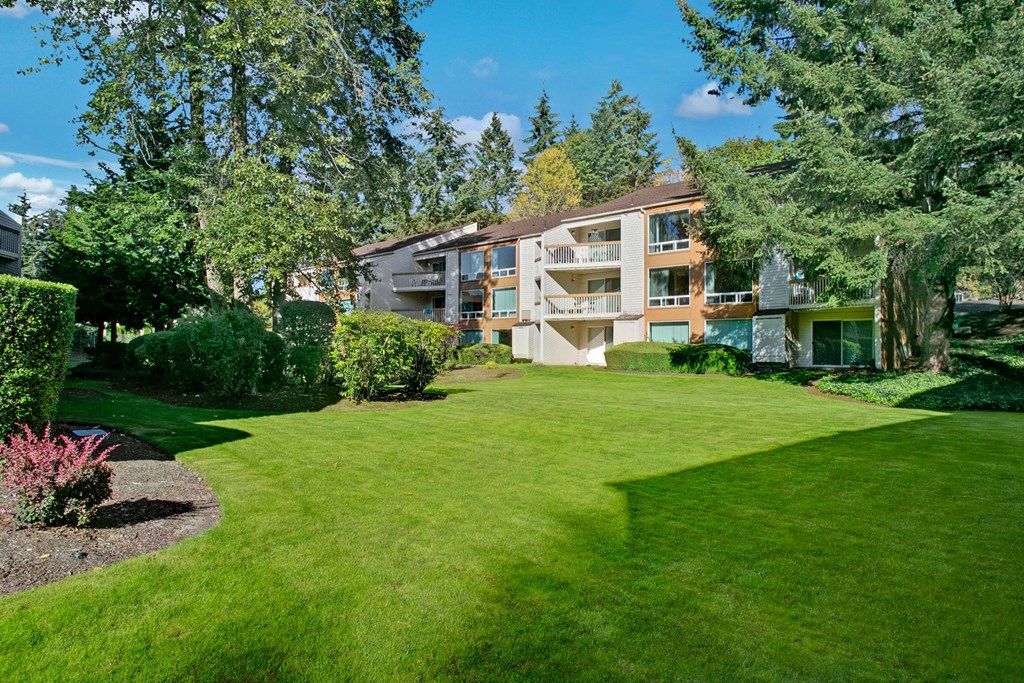Exterior of the buildings with a well-maintaned lawn and trees Adagio Exterior Apartments in Bellevue, WA