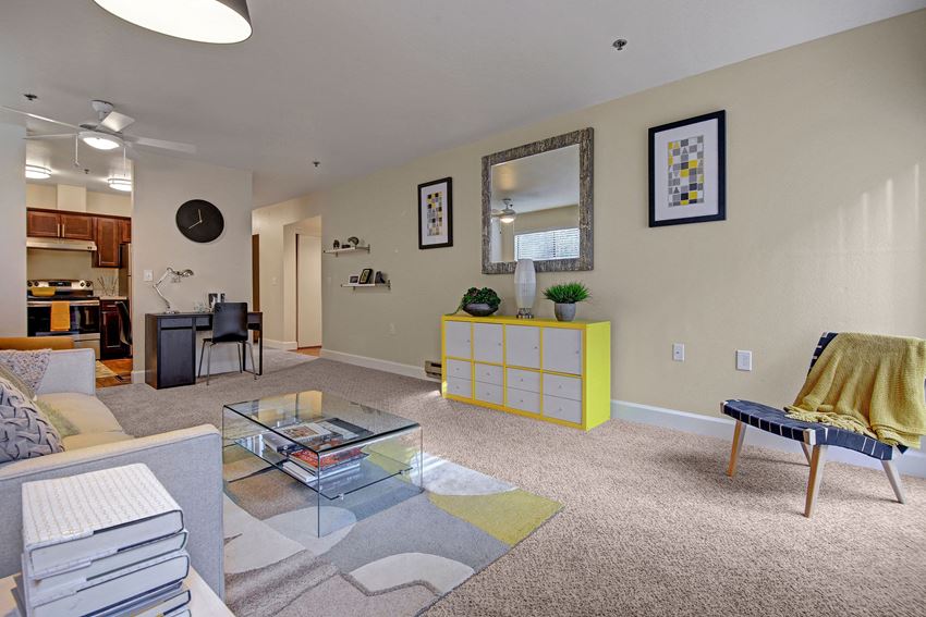 Living room with couch, desk, and view into the kitchen Foster Greens Living Room Apartments in Tukwila, WA