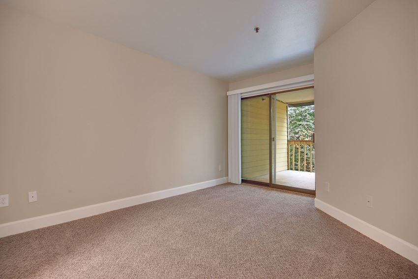 Large living area with sliding glass doors out to the balcony Foster Greens Living Room Apartments in Tukwila, WA
