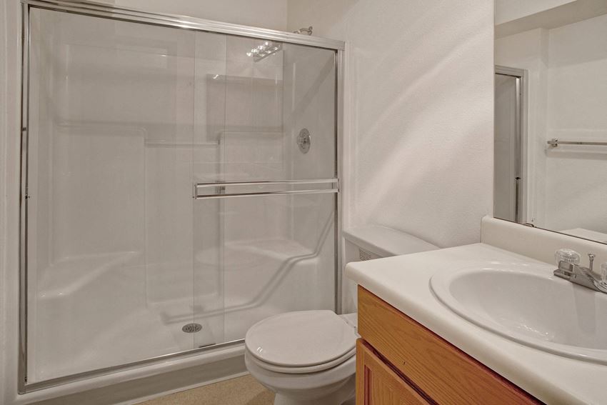 A bathroom with cabinet storage and a large standing shower Lake Park Bathroom Apartments in Everett, WA