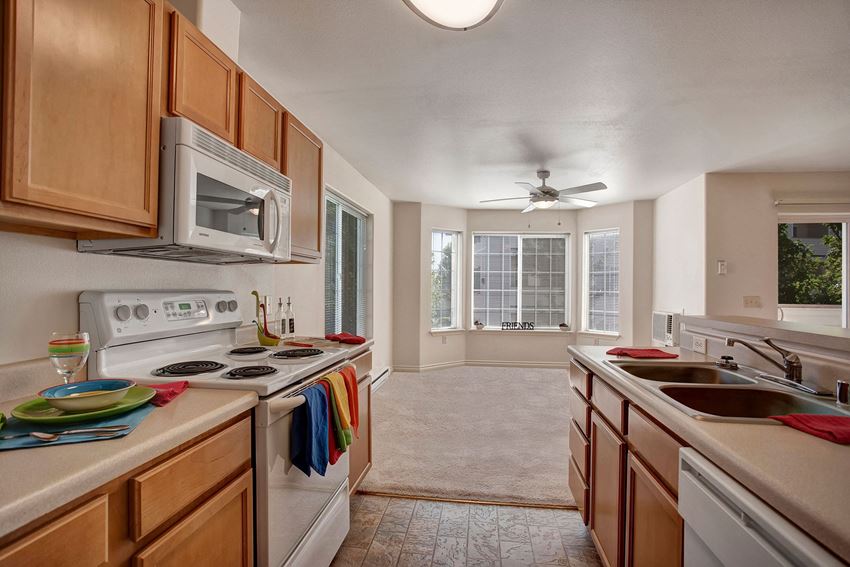 A kitchen with plenty of counter space, a breakfast bar, lots of cabinet storage space, and a view into the dining area Lion's Gate Kitchen