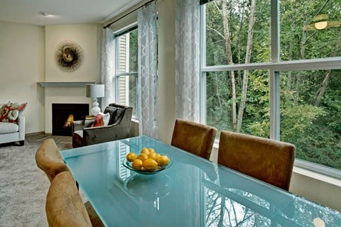 a living room with a glass table with a bowl of fruit on it