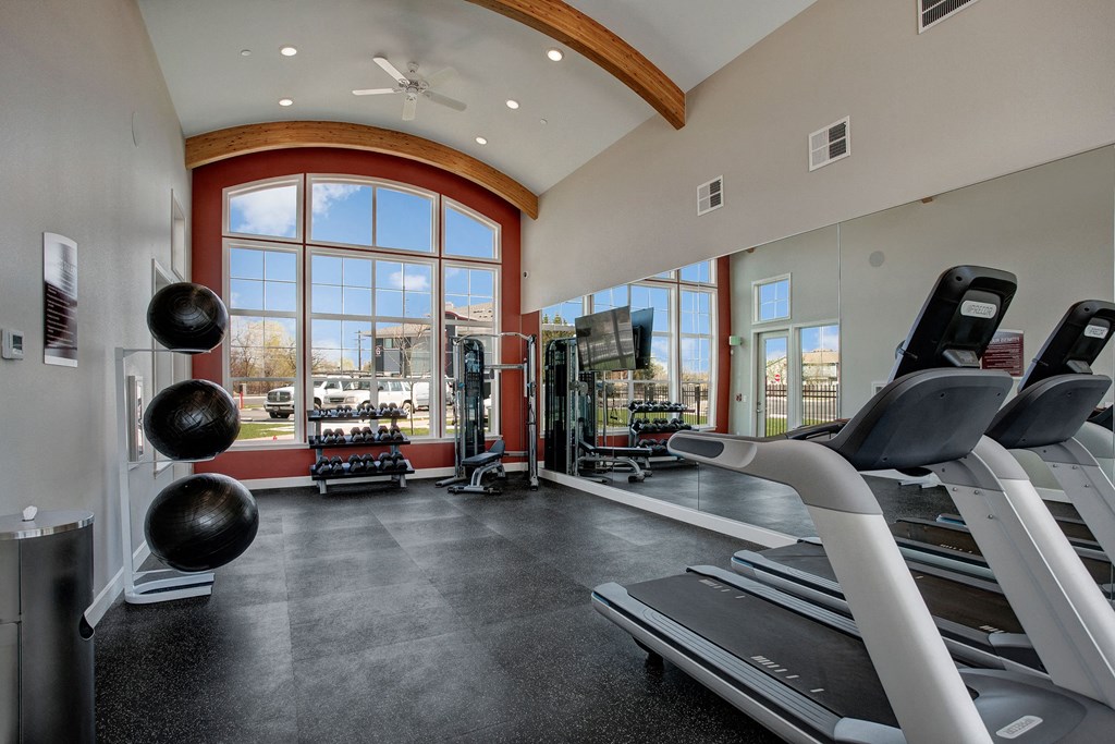 A large, open gym with treadmills, dumbbells, medicine balls, and a flat screen TV Solara Gym Apartments in Moses Lake, WA