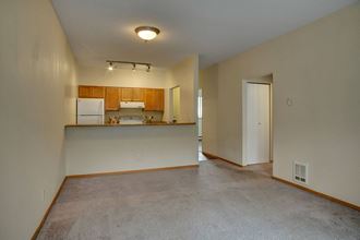 A large living room with a view into the kitchen over the bar St James Tower Living Room Apartments in Seattle, WA