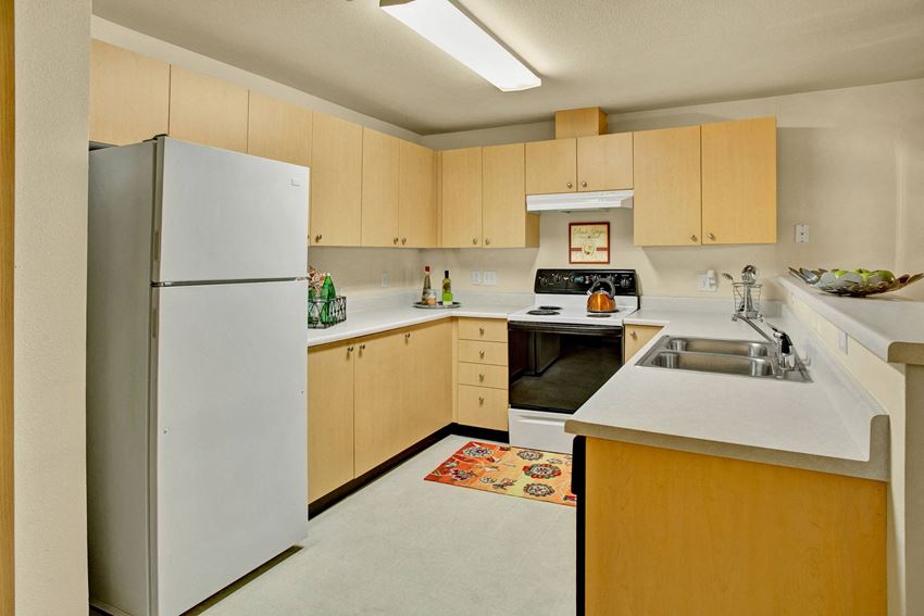 A kitchen with lots of counter space cabinet storage, and a bar Sunrise Lane Kitchen Apartments in Everett, WA - Photo Gallery