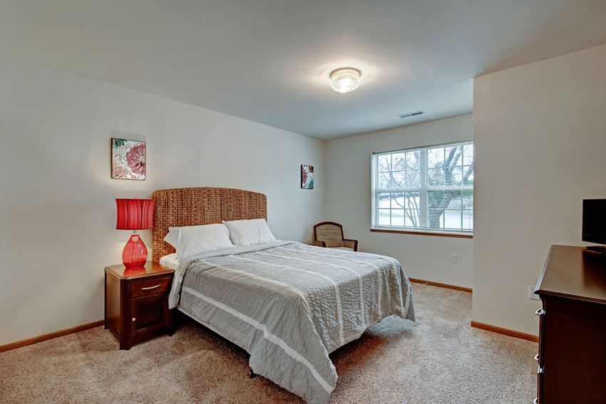 Arbor Ridge Bedroom View with Red Lamp and Window Arbor Ridge Bedroom View, Weidner Real Estate Properties Apartments for rent Milwaukee, WI