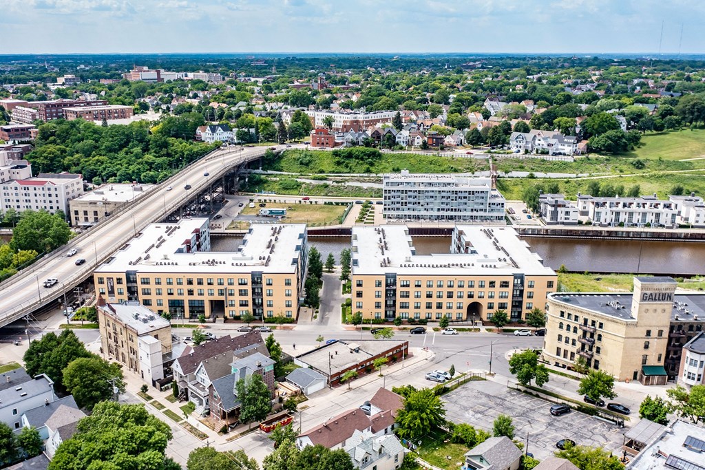 Aerial view of a cityscape featuring a large bridge over a river. Surrounding the river is River House Apartments, set amidst lush greenery.