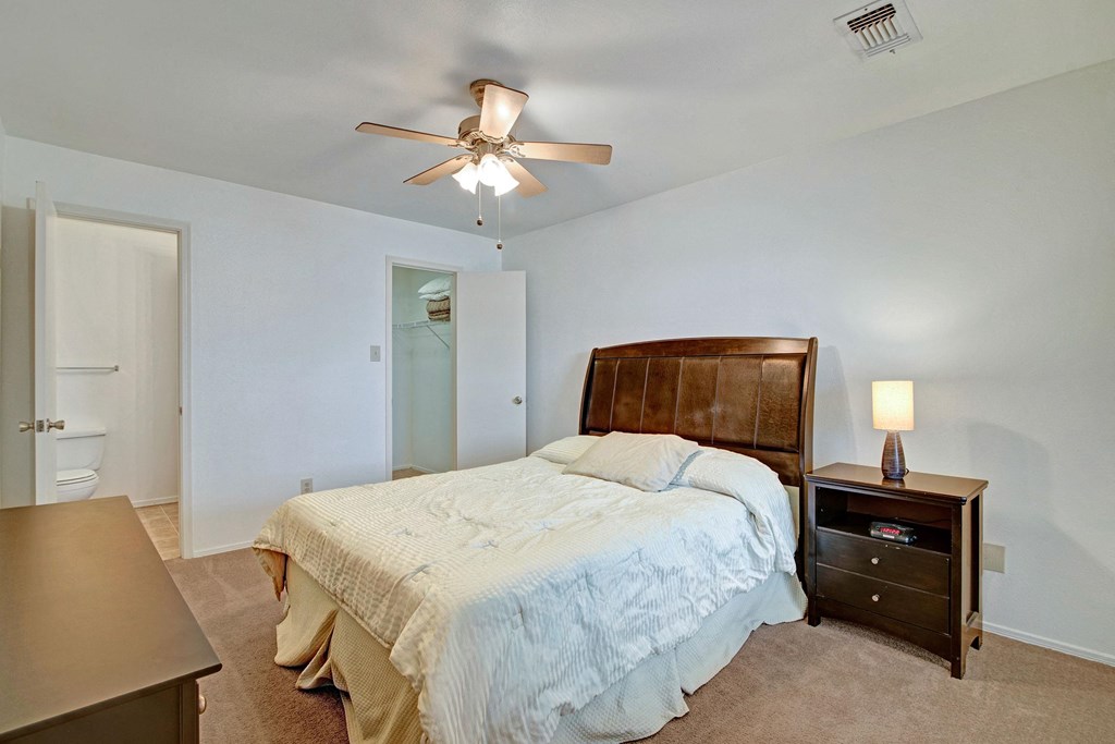 a bedroom St. James Place Bedroom Apartments in Milwaukee, WIwith a large bed and a ceiling fan