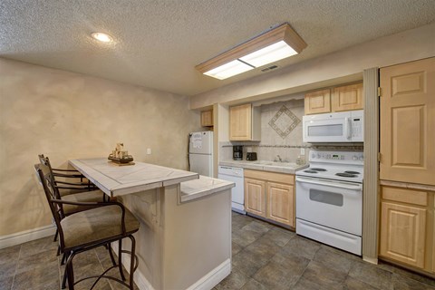 A kitchen with a table and chairs in it.