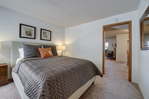 A bedroom with a large bed and two pictures on the wall.